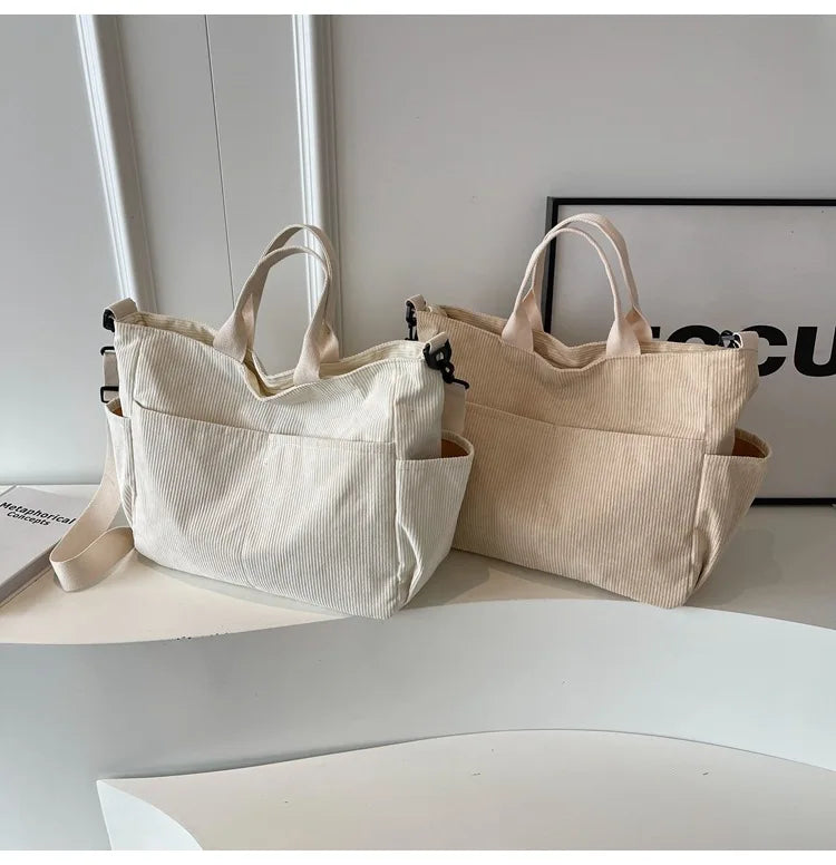 A pair of beige corduroy multi-pocket tote bags displayed on a white surface.