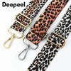 A close-up of a leopard print adjustable strap for bags featuring gold-toned buckles.