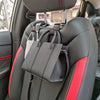Black car seat back hooks with a red accent strap are visible inside a vehicle.