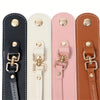 A set of four vintage leather glove holder straps in black, cream, pink, and brown.