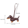 A brown leather dachshund dog charm keychain with a loop, shown in profile view.