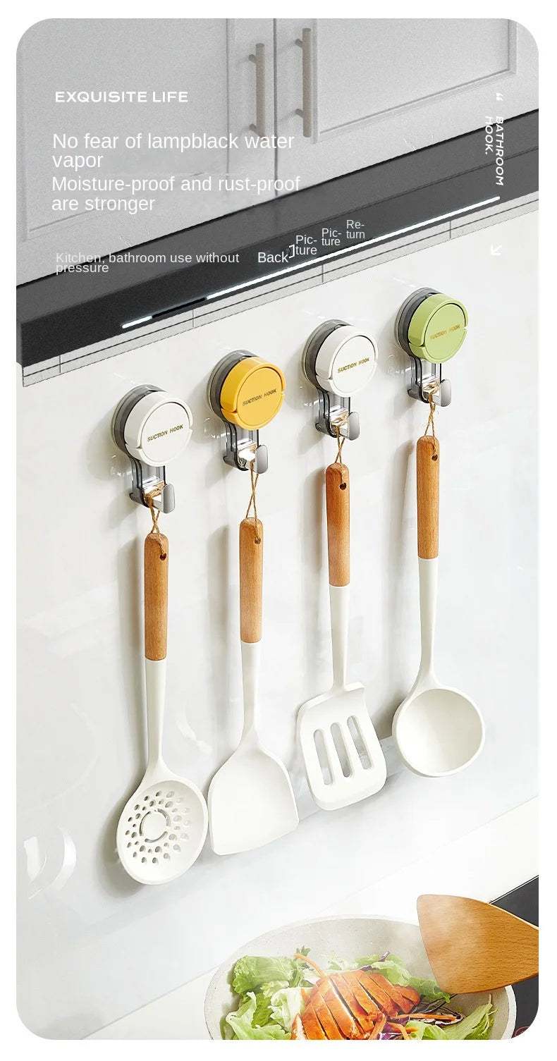 A set of silicone and wood traceless suction cup hooks for kitchen use mounted on a white cabinet door.