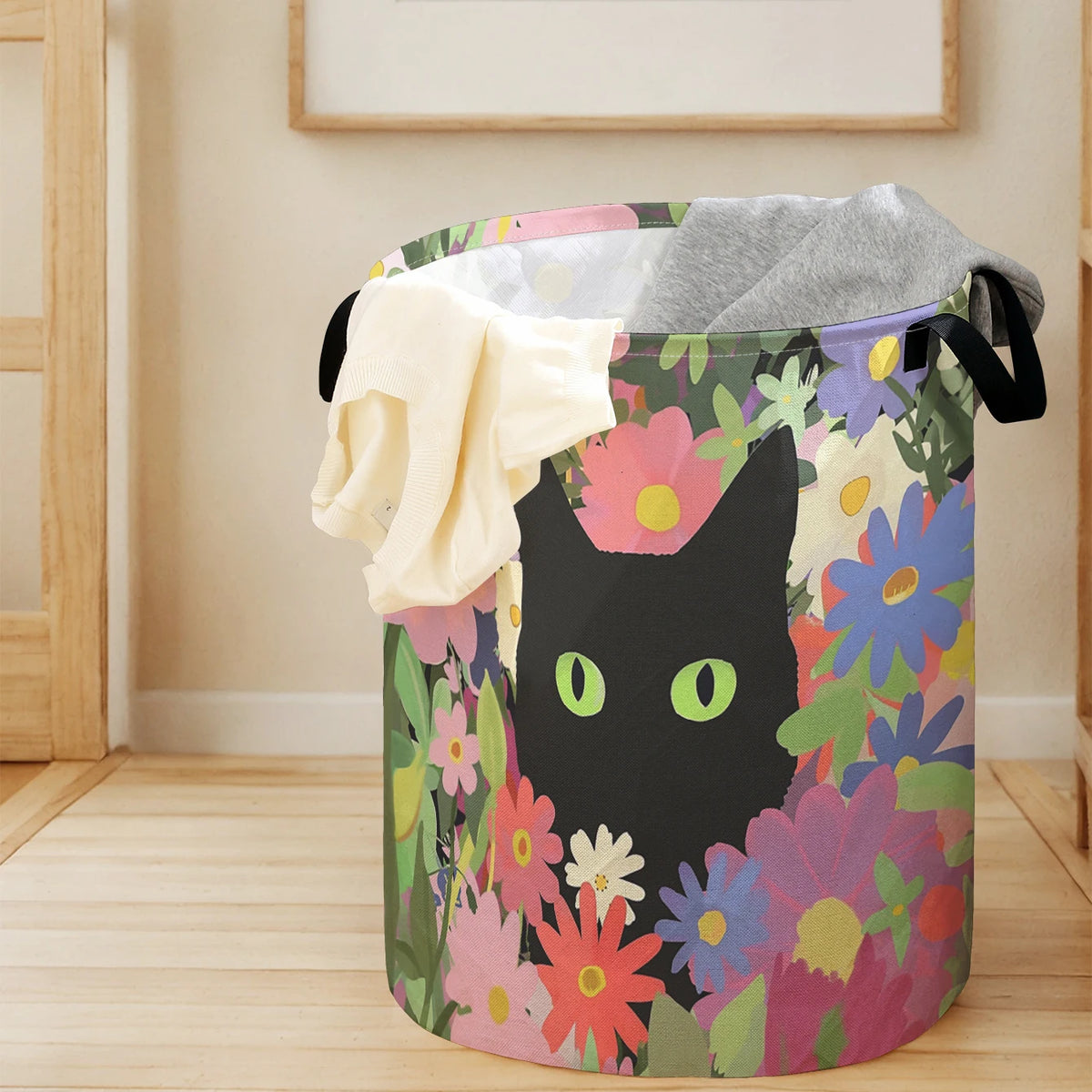 A purple storage basket filled with folded gray and cream textiles featuring a floral pattern with a black cat face.