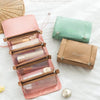 A set of portable detachable makeup bags in pink and green, with a woven straw bag nearby.