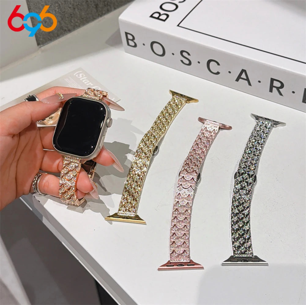 A hand displays a crystal fishscale apple watch band with sparkling metal strap on a black Apple Watch.