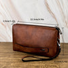 Portefeuille pochette en cuir marron posé sur une surface en bois avec des lignes de mesure.