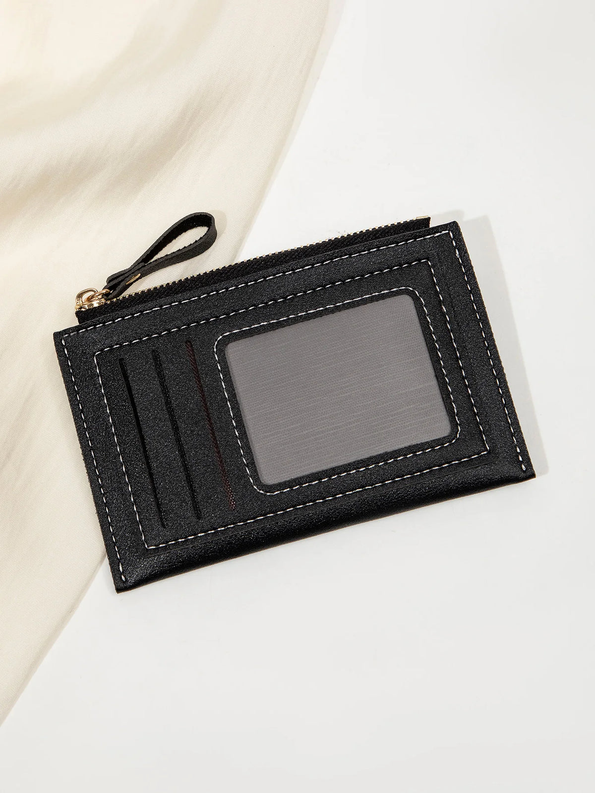Portefeuille en cuir PU noir minimaliste avec rabat et fenêtre transparente sur fond blanc.