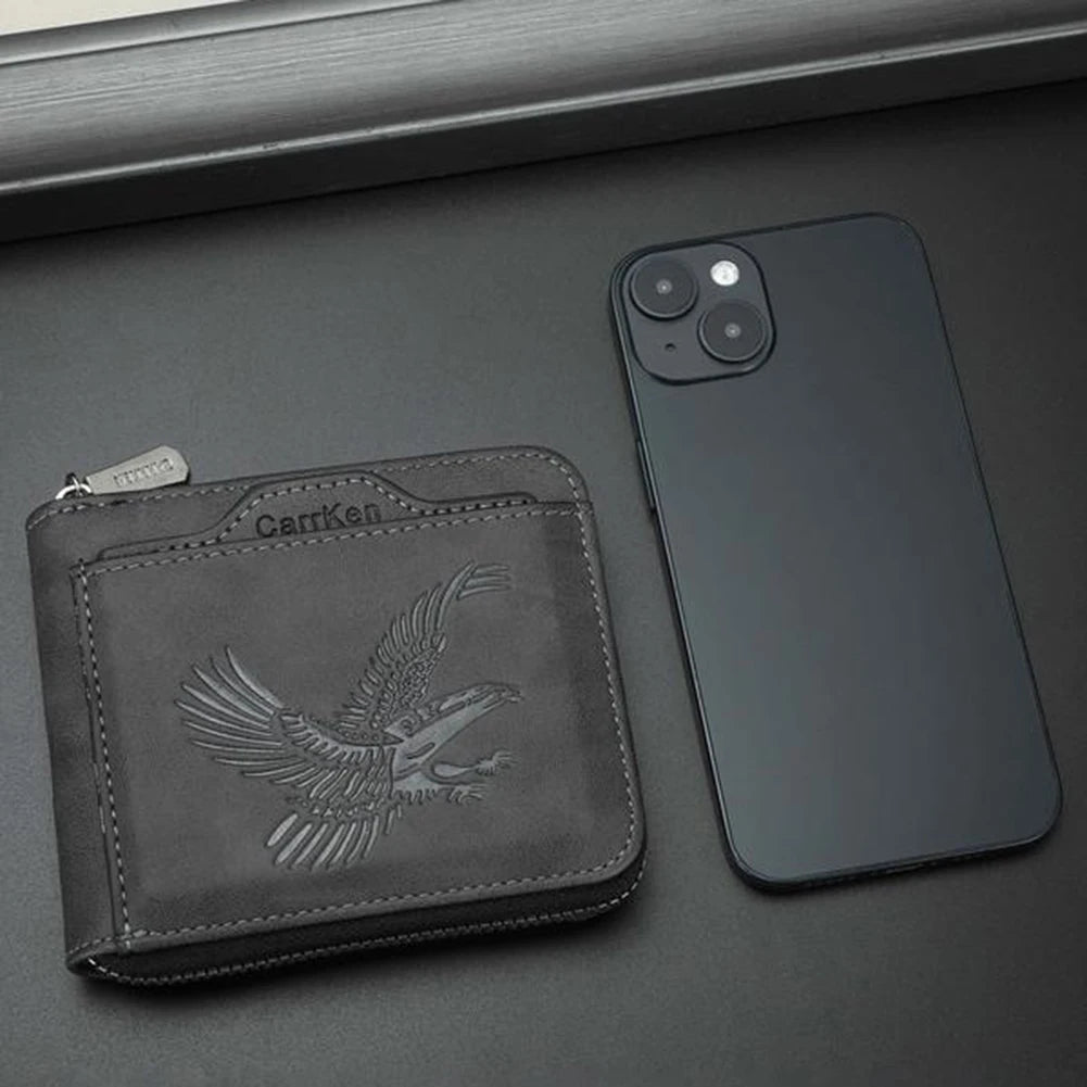 Cartera de tarjetas vintage negra con relieve para hombre junto a un smartphone oscuro.