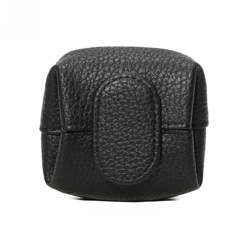Black compact coin purse with a textured leather finish and snap closure.