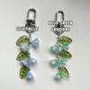 Pair of silver-hooked keychains featuring a blue to green gradient design with lily of the valley flowers.
