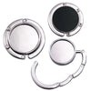 Gancho de bolsa plegable plateado con superficie de espejo circular para organizar artículos.