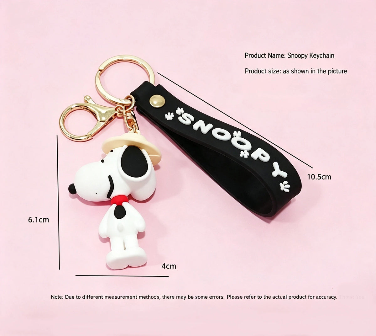 A black keychain featuring a white Snoopy figure attached to a gold ring.