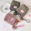 A collection of leopard print makeup bags and a skincare organizer with pink accents on a white background.