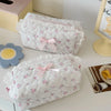 White quilted cosmetic storage pouches with pink floral embroidery and ribbon