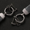 A close-up of a silver carbon fiber leather keychain with a metal clasp and ring.