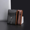 Un porte-monnaie bi-pli en fibre de carbone marron et noir présenté sur une surface sombre.