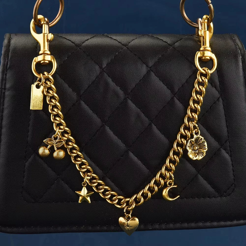 A black quilted shoulder bag with a gold chain necklace featuring cherry flower and crescent moon charms
