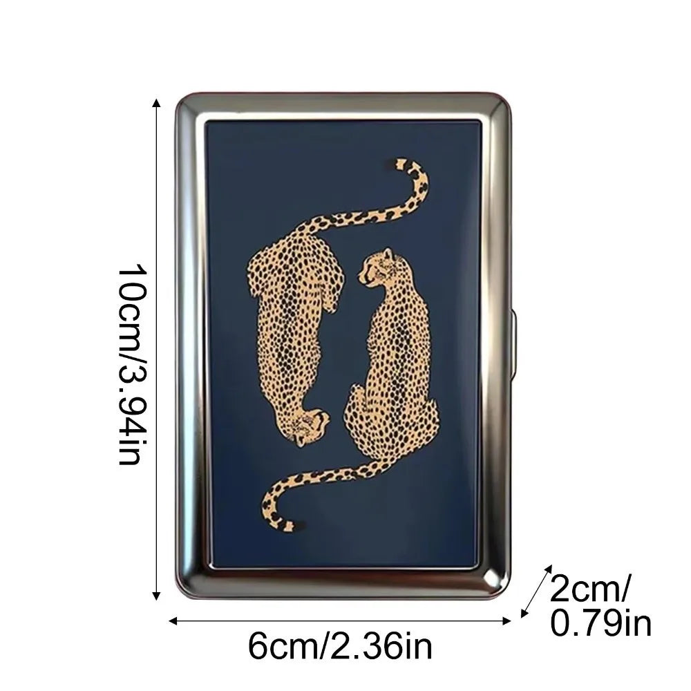 A vintage metal card holder featuring a gold-colored leopard or cheetah print design on a dark blue background.