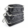 A set of three black reusable compression packing cubes stacked together.