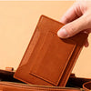 Un porte-monnaie de voyage mince en cuir brun étant placé dans un sac.
