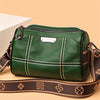 A dark green luxury cowhide shoulder bag with brown leather strap and white stitching.