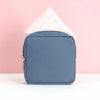Schieferblaue tragbare Tasche zum Aufbewahren von Tampons, mit einem rosa gemusterten Tampon sichtbar.