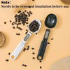A black digital kitchen scale is shown next to spilled coffee beans on a light background.