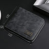 A black leather zipper wallet with a gold engraved nameplate shown on a dark surface.